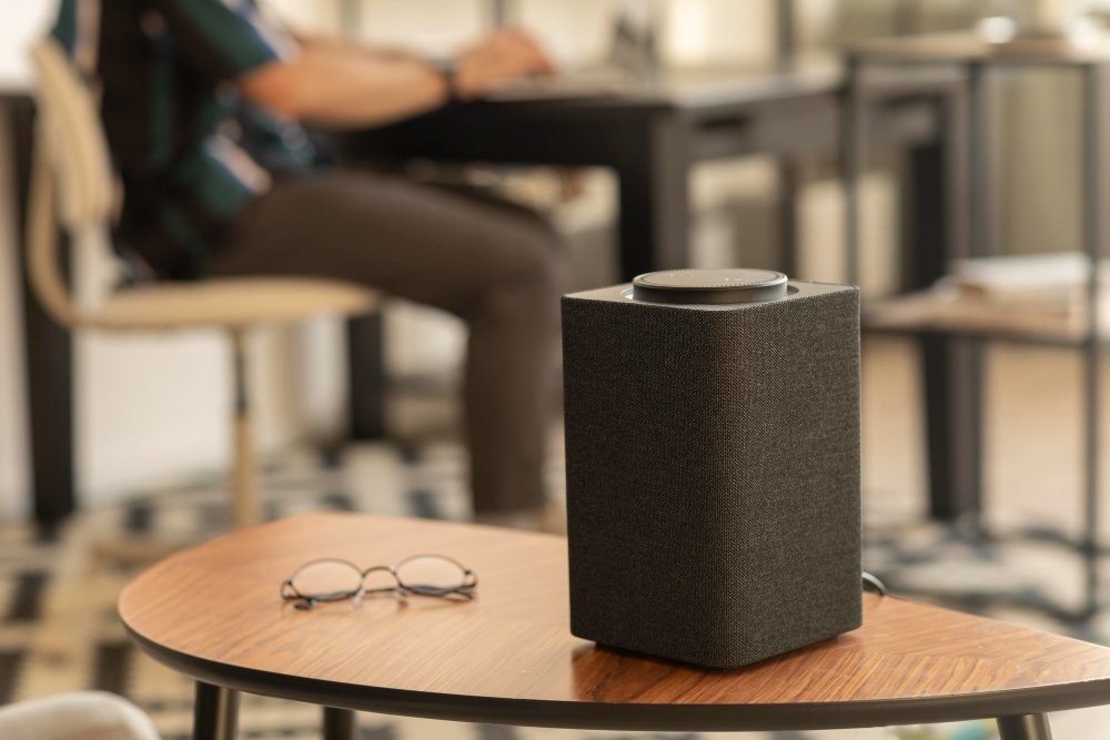 Altavoz Bluetooth portátil de gama alta en una mesa, ideal para música en casa y exteriores.